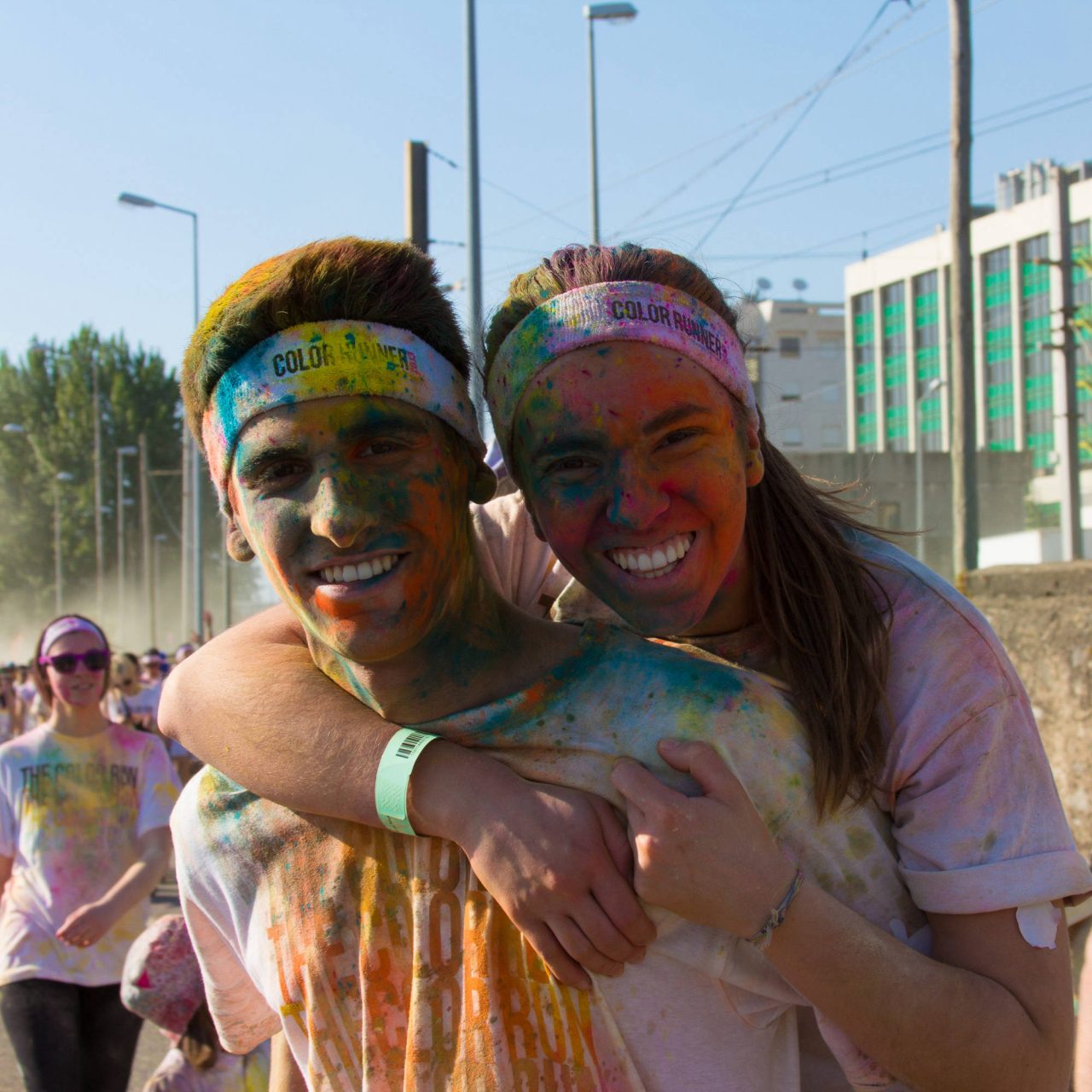 Two smiling young women with their faces covered in bright festival powder