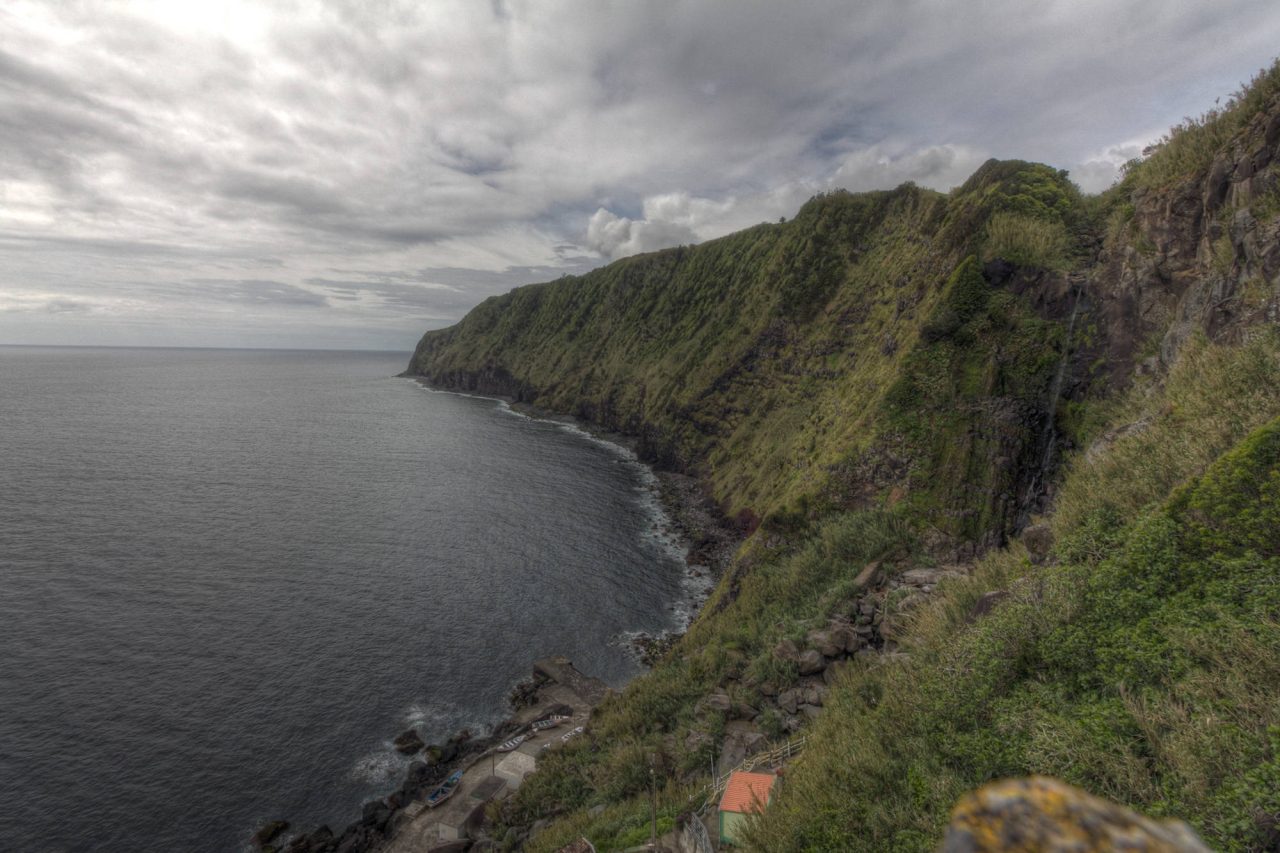 Steep green cliffs dropping into the ocean along a rugged coastline